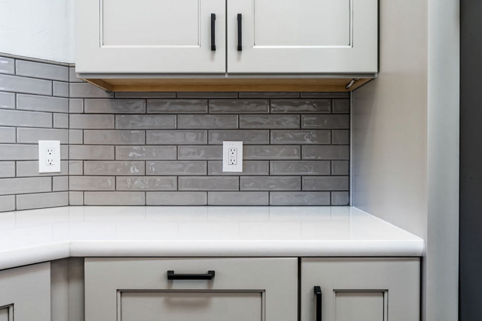 Large transitional u-shaped vinyl floor and gray floor eat-in kitchen photo with an undermount sink, shaker cabinets, gray cabinets, quartzite countertops, green backsplash, subway tile backsplash, stainless steel appliances, an island and white countertops