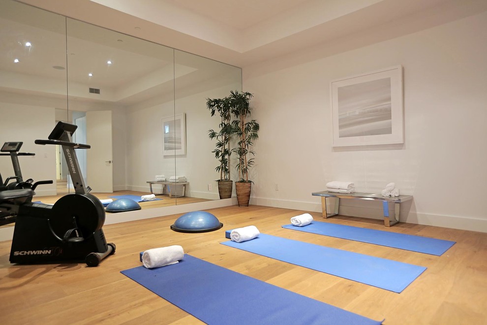 Design ideas for a mid-sized modern home yoga studio in Los Angeles with white walls and medium hardwood floors.