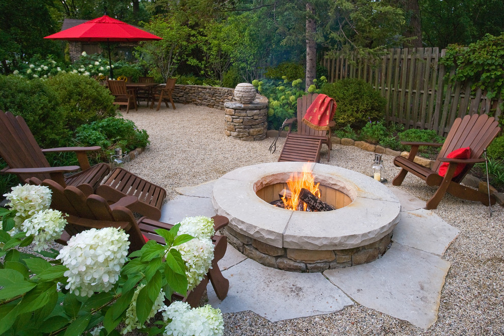 Inspiration for a small country backyard patio in Chicago with a fire feature and gravel.