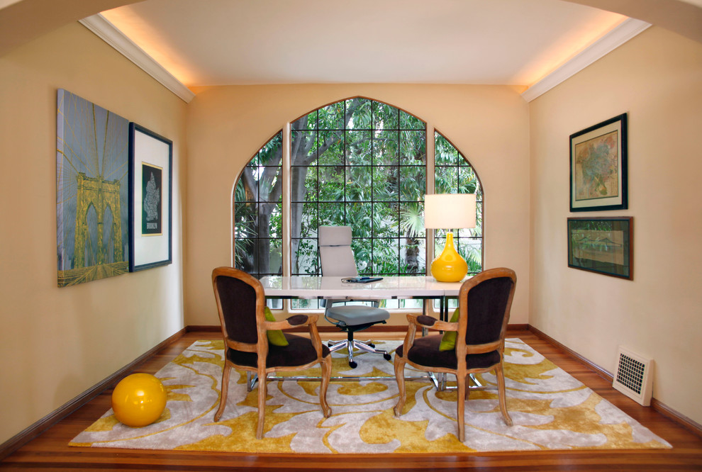 This is an example of a mid-sized transitional study room in San Francisco with beige walls, medium hardwood floors and a freestanding desk.