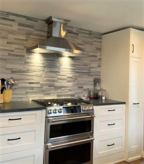 Example of a mid-sized transitional enclosed kitchen design in Seattle with shaker cabinets, white cabinets and black countertops