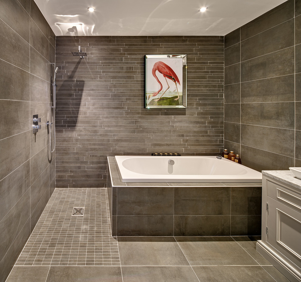 This is an example of a mid-sized contemporary wet room bathroom in Dublin with an open shower, a drop-in tub and brown tile.