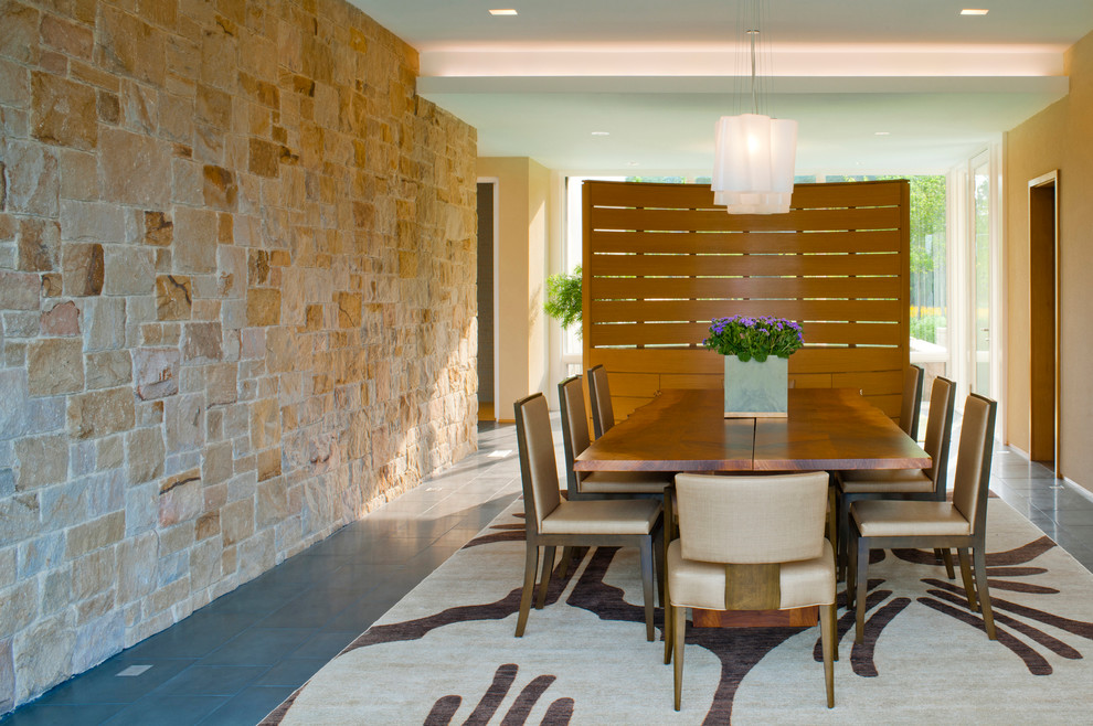 This is an example of a modern dining room in DC Metro with beige walls and slate floors.