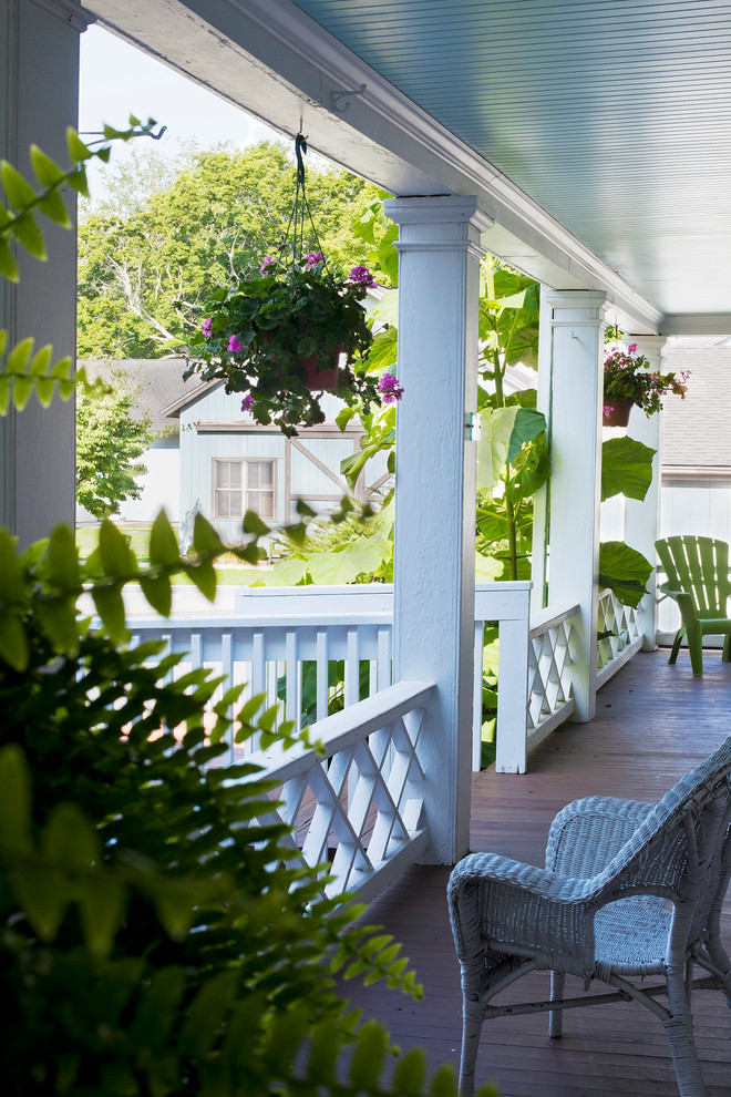 Mid-sized traditional front yard verandah in New York with decking, a roof extension and a container garden.