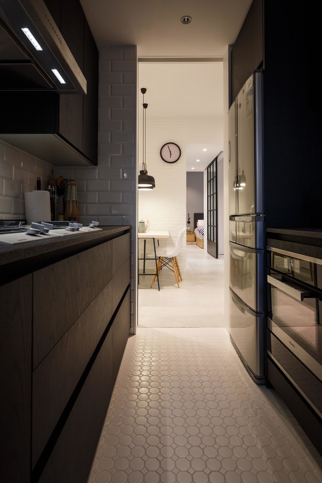 Inspiration for a small modern u-shaped kitchen in Hong Kong with a double-bowl sink, dark wood cabinets, black splashback, black appliances and ceramic floors.