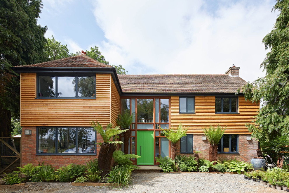 This is an example of a large and brown world-inspired two floor front detached house in Buckinghamshire with wood cladding.