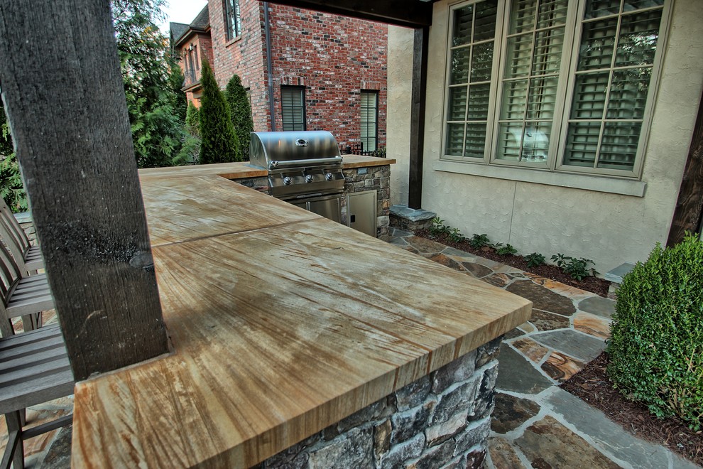 Photo of a mid-sized traditional backyard patio in Charlotte with natural stone pavers.