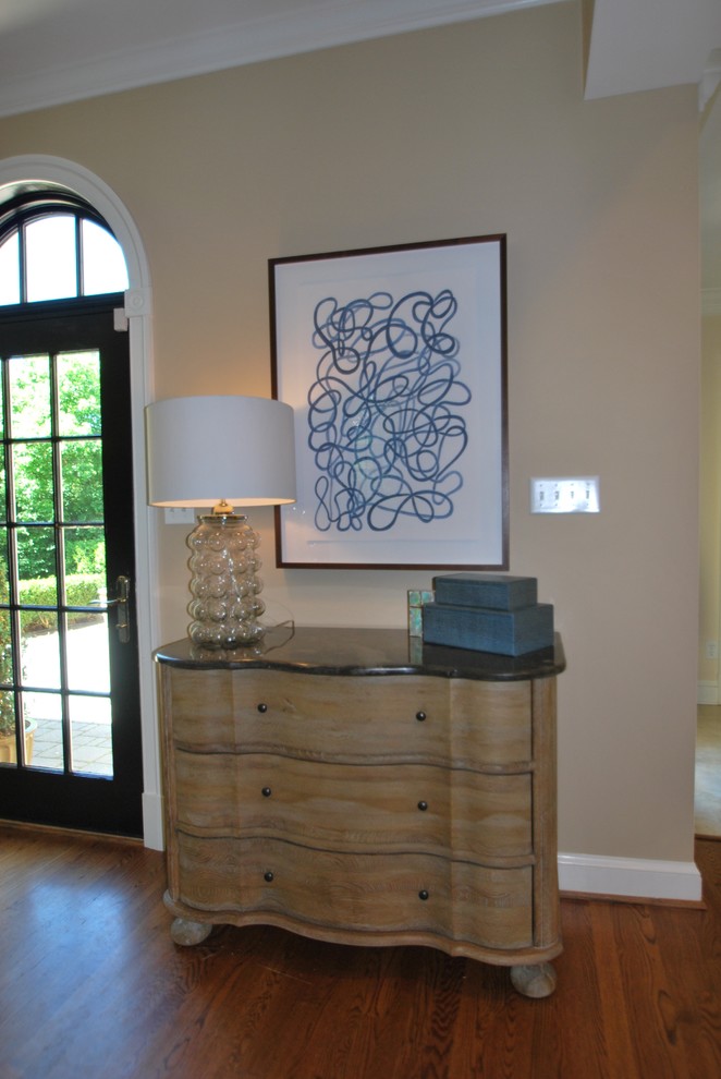 Example of a mid-sized transitional open concept dark wood floor and brown floor entryway design in DC Metro with beige walls, a standard fireplace and a stone fireplace