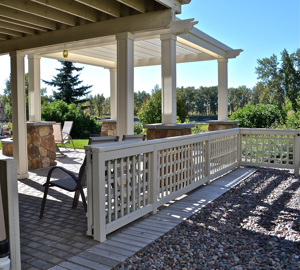 Photo of a mid-sized traditional backyard patio in Calgary with gravel and a pergola.