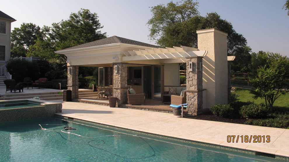 This is an example of a large contemporary backyard rectangular pool in Philadelphia with tile and a hot tub.