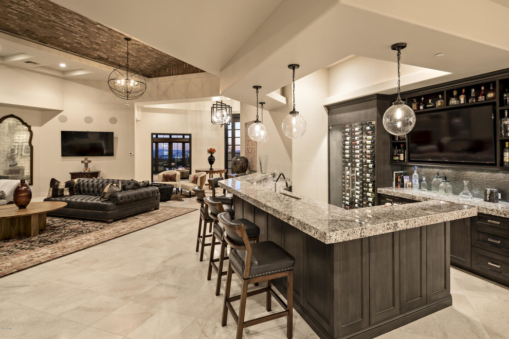 This is an example of a large contemporary wine cellar in Phoenix with travertine floors and display racks.