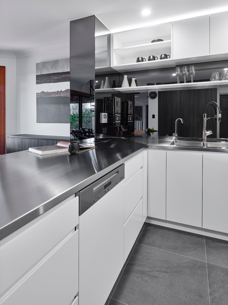 Inspiration for a large modern u-shaped eat-in kitchen in Other with an integrated sink, white cabinets, stainless steel benchtops, glass sheet splashback, stainless steel appliances, ceramic floors and a peninsula.