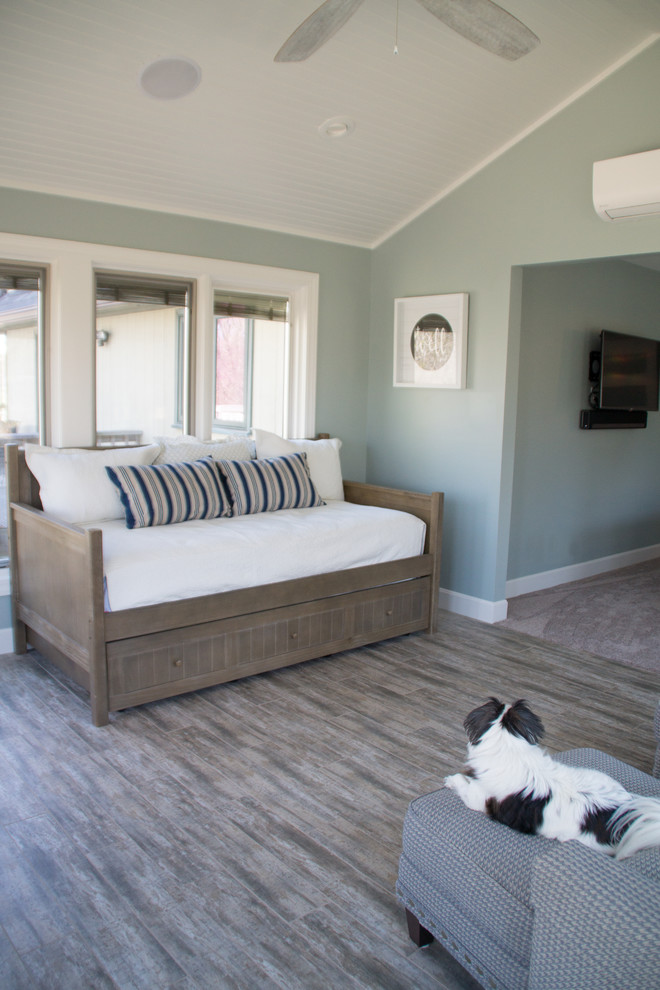 This is an example of a large beach style master bedroom in Other with green walls, porcelain floors, no fireplace and grey floor.