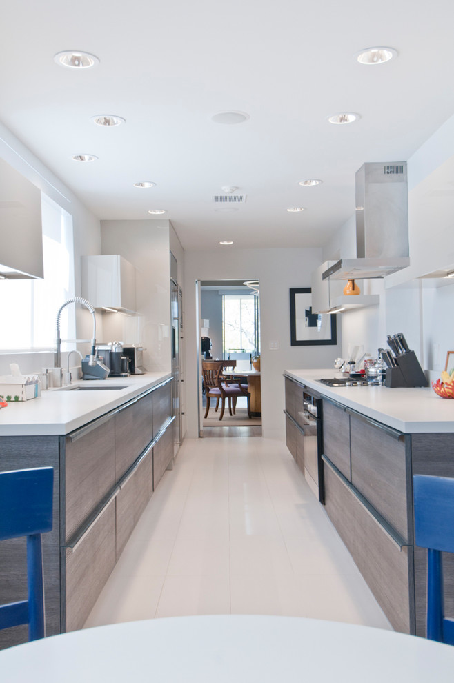 Photo of a mid-sized modern galley eat-in kitchen in Los Angeles with an undermount sink, flat-panel cabinets, grey cabinets, quartzite benchtops, red splashback, stainless steel appliances, porcelain floors, no island and turquoise floor.