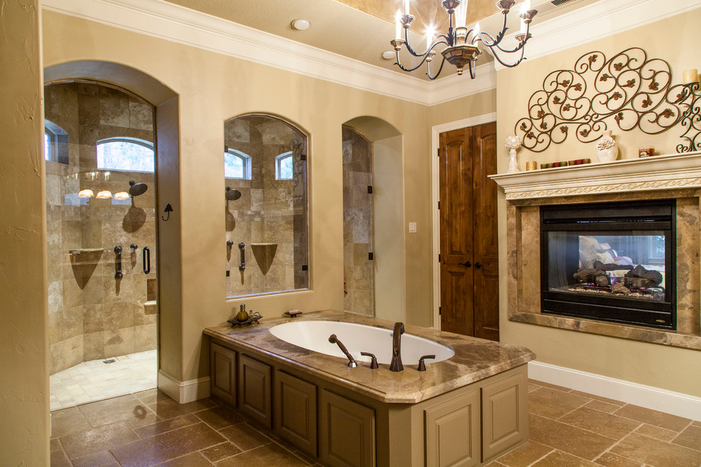 Inspiration for a large transitional master bathroom in Houston with raised-panel cabinets, an undermount sink, granite benchtops, an undermount tub, an open shower, a one-piece toilet, grey cabinets, marble, beige walls and travertine floors.