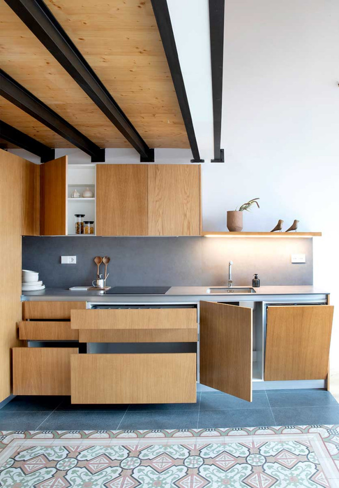 Свежая идея для дизайна: кухня-гостиная в стиле модернизм с плоскими фасадами, фасадами цвета дерева среднего тона и столешницей из нержавеющей стали - отличное фото интерьера