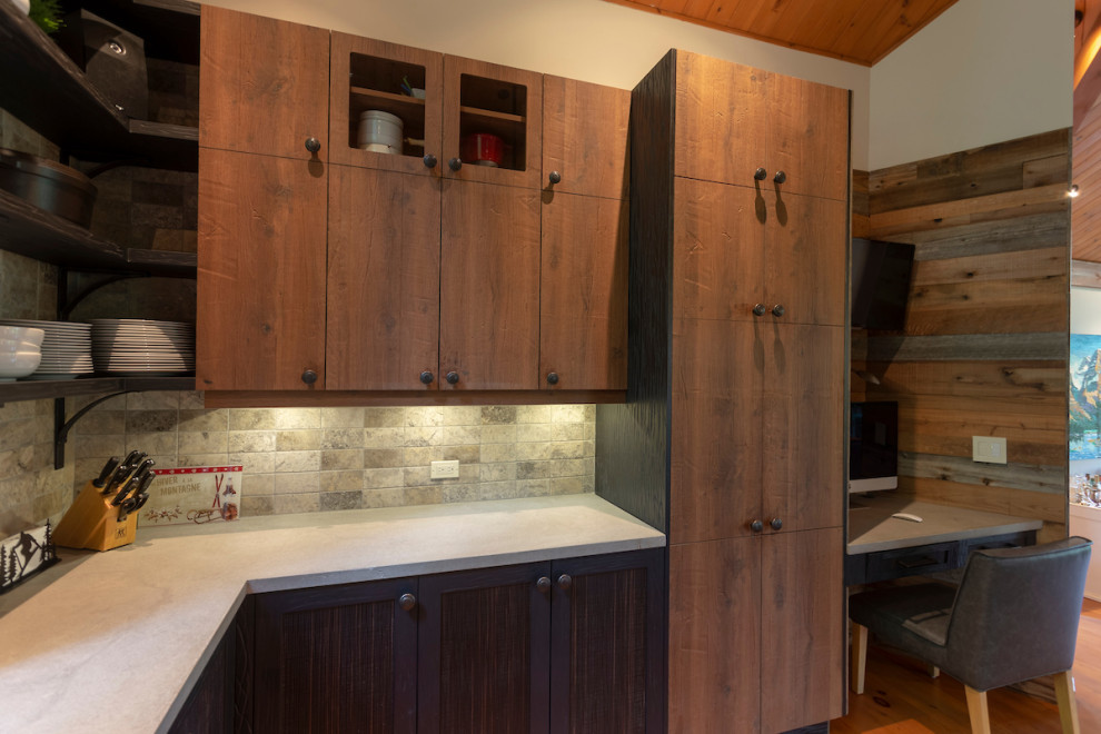 Photo of a mid-sized country u-shaped eat-in kitchen in Montreal with a farmhouse sink, flat-panel cabinets, medium wood cabinets, concrete benchtops, grey splashback, stone tile splashback, stainless steel appliances, medium hardwood floors, with island, orange floor and grey benchtop.