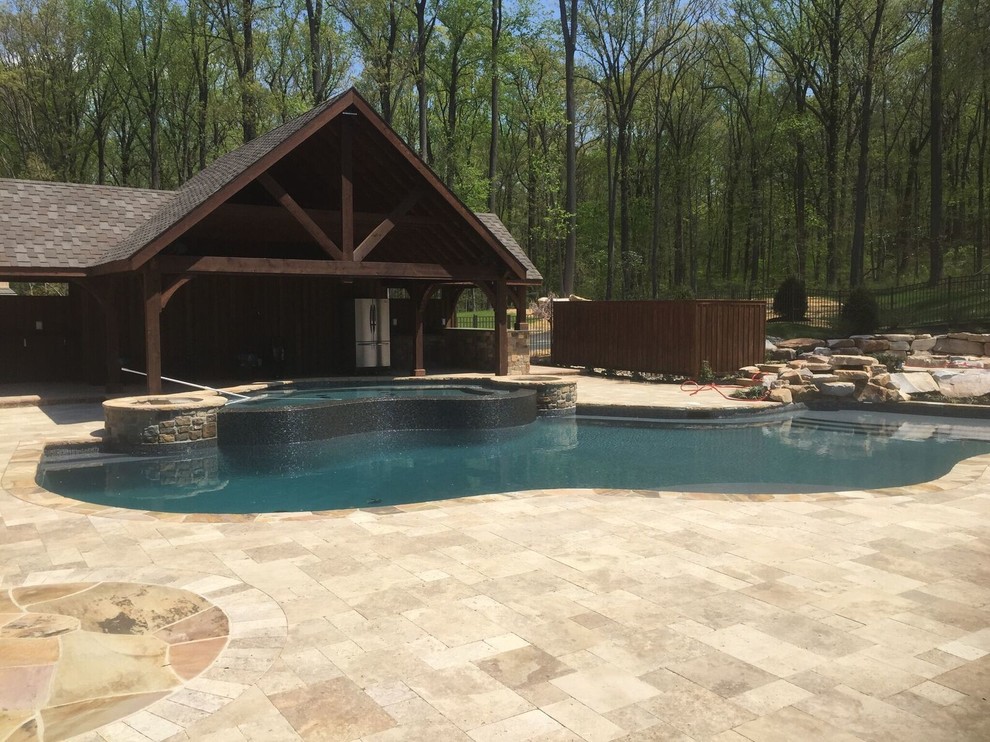 Design ideas for a large contemporary backyard custom-shaped natural pool in Philadelphia with natural stone pavers and a pool house.