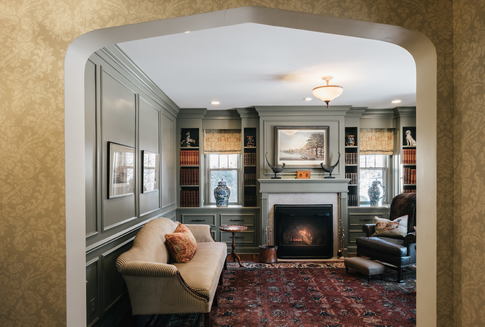 Photo of a mid-sized traditional study room in Minneapolis with dark hardwood floors, a standard fireplace, a wood fireplace surround, a freestanding desk and grey walls.