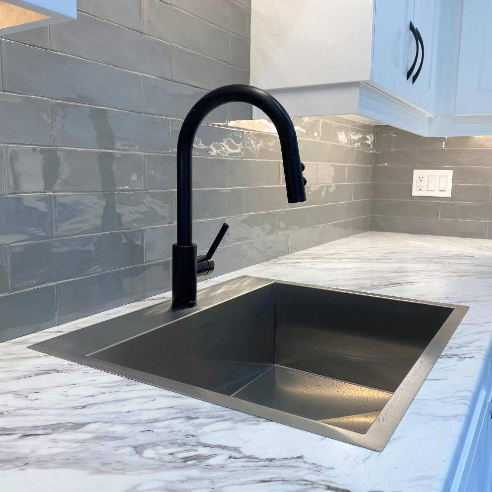 Mid-sized transitional galley vinyl floor eat-in kitchen photo in Toronto with a drop-in sink, shaker cabinets, white cabinets, laminate countertops, gray backsplash and stainless steel appliances