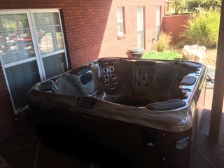 Inspiration for a mid-sized transitional backyard concrete and rectangular hot tub remodel