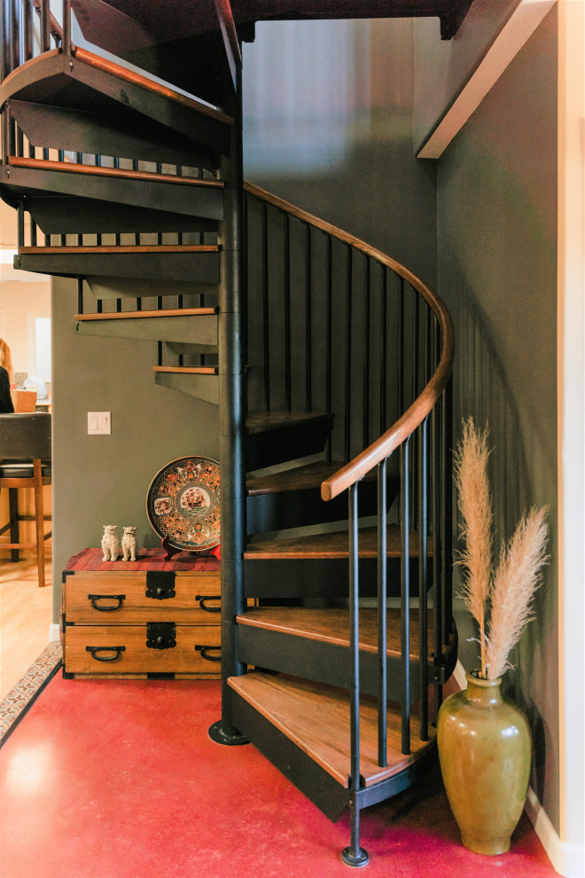 На фото: винтовая металлическая лестница в стиле фьюжн с деревянными ступенями и перилами из смешанных материалов