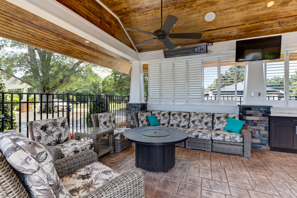Large beach style backyard patio in Raleigh with an outdoor kitchen, stamped concrete and a gazebo/cabana.