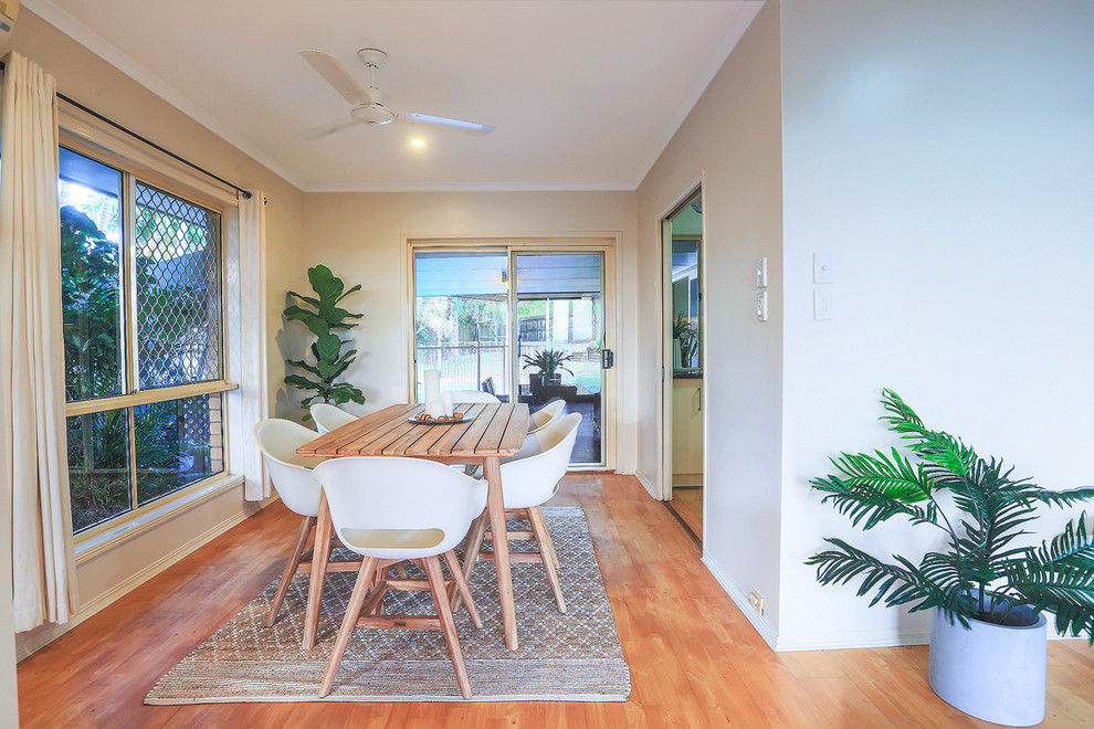 Design ideas for a beach style dining room in Brisbane with beige walls, medium hardwood floors and beige floor.