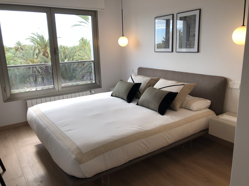 Inspiration for a scandinavian master bedroom in Alicante-Costa Blanca with white walls and light hardwood floors.