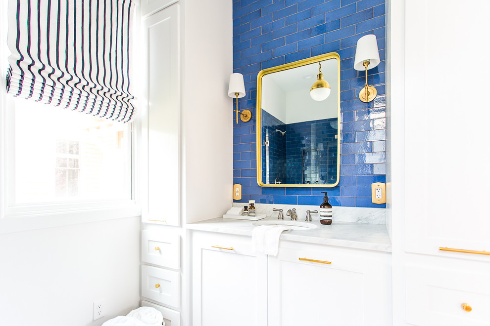 Inspiration for a mid-sized modern 3/4 bathroom in Oklahoma City with recessed-panel cabinets, white cabinets, an open shower, blue tile, ceramic tile, white walls, ceramic floors, a drop-in sink, marble benchtops, white floor and white benchtops.