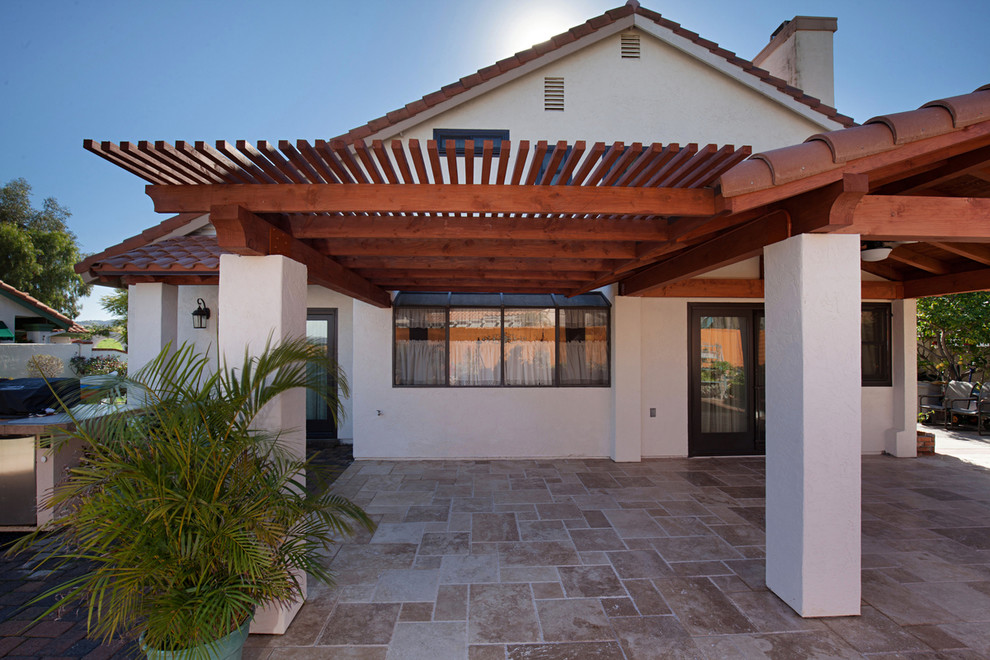 Inspiration for a large traditional two-storey adobe beige house exterior in San Diego with a gambrel roof, a tile roof and a red roof.