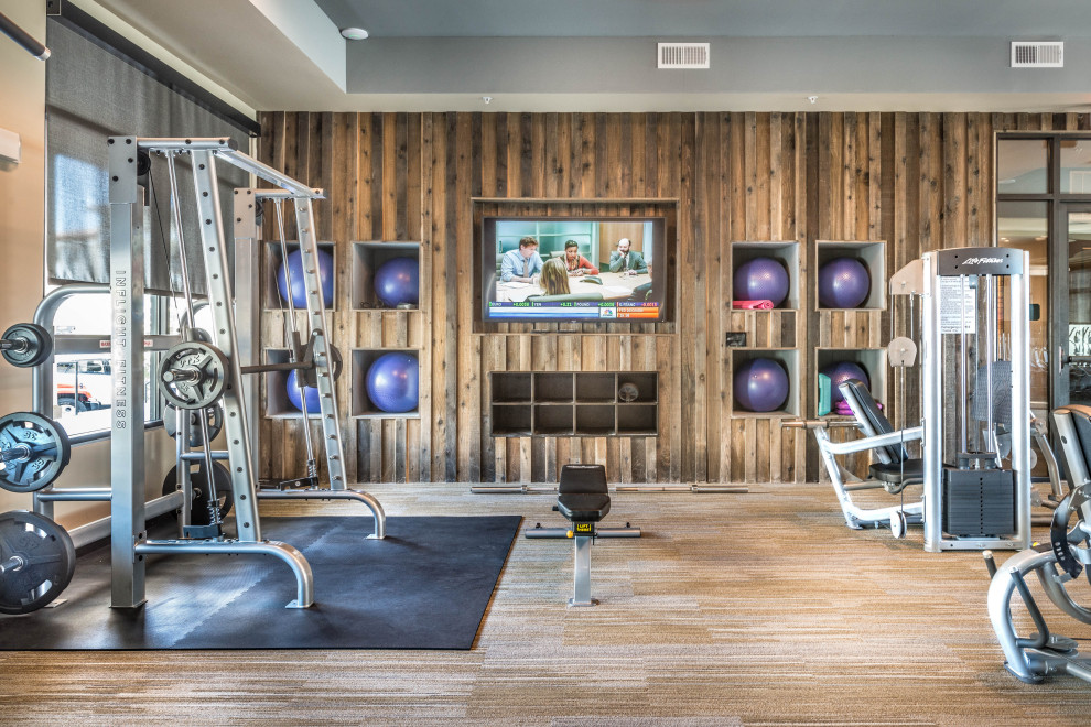 This is an example of a country home gym in Dallas with brown walls, carpet and brown floor.
