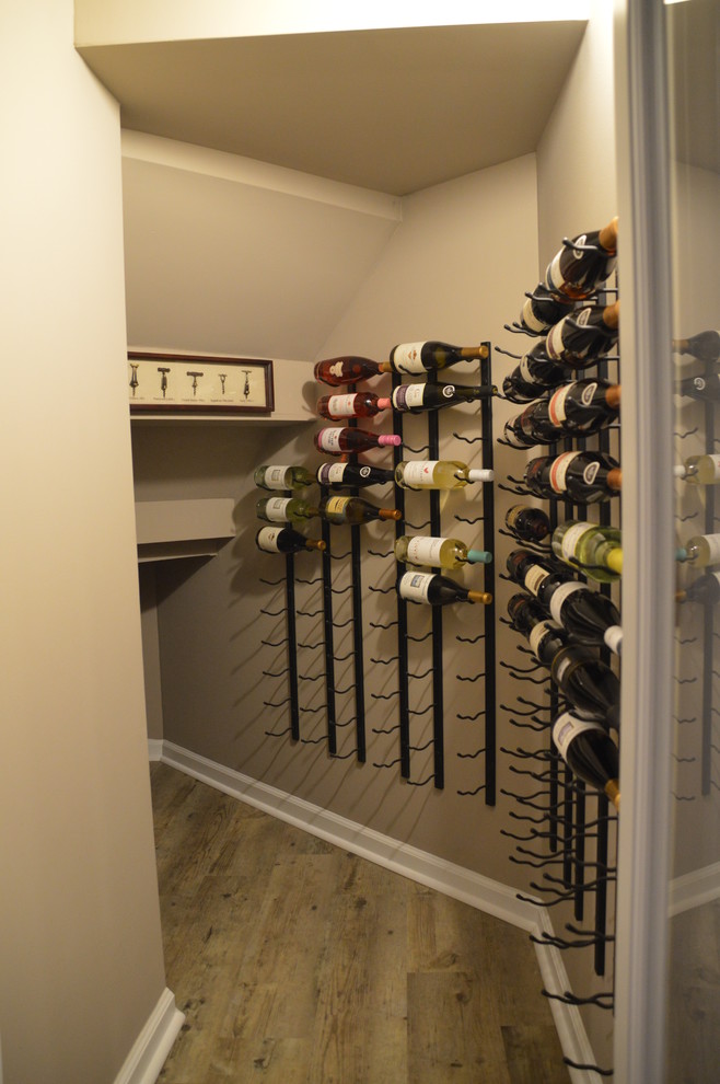 Design ideas for a small modern wine cellar in Detroit with vinyl floors, storage racks and brown floor.