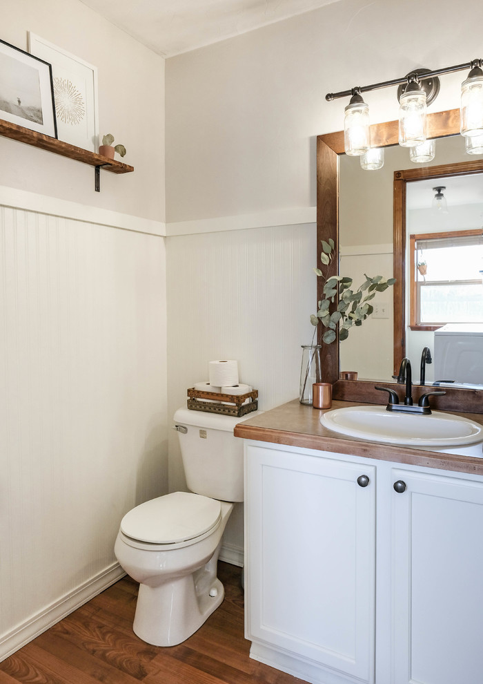 This is an example of a mid-sized country 3/4 bathroom in Other with raised-panel cabinets, white cabinets, white tile, laminate benchtops and beige benchtops.