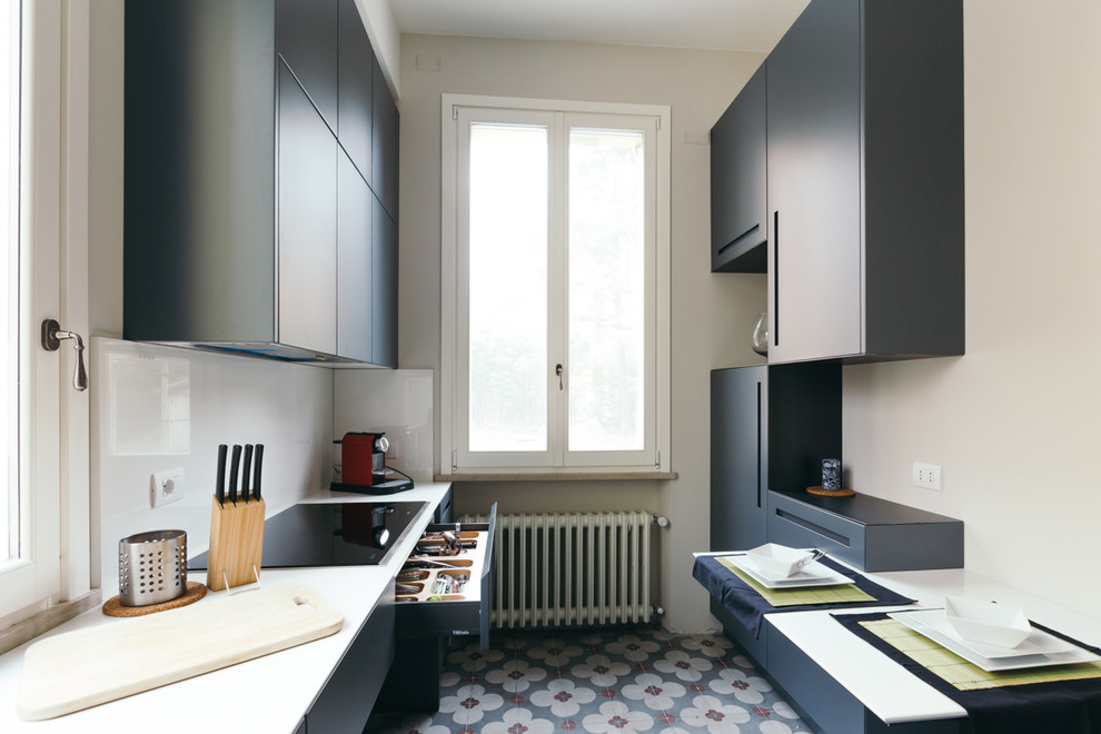 Mid-sized contemporary galley kitchen in Bologna with flat-panel cabinets, blue cabinets, white splashback, ceramic floors, multi-coloured floor and glass sheet splashback.