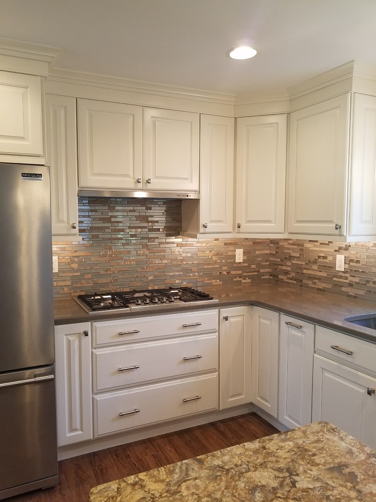 Inspiration for a mid-sized transitional l-shaped dark wood floor open concept kitchen remodel in Baltimore with an undermount sink, raised-panel cabinets, white cabinets, granite countertops, metallic backsplash, matchstick tile backsplash, stainless steel appliances and an island