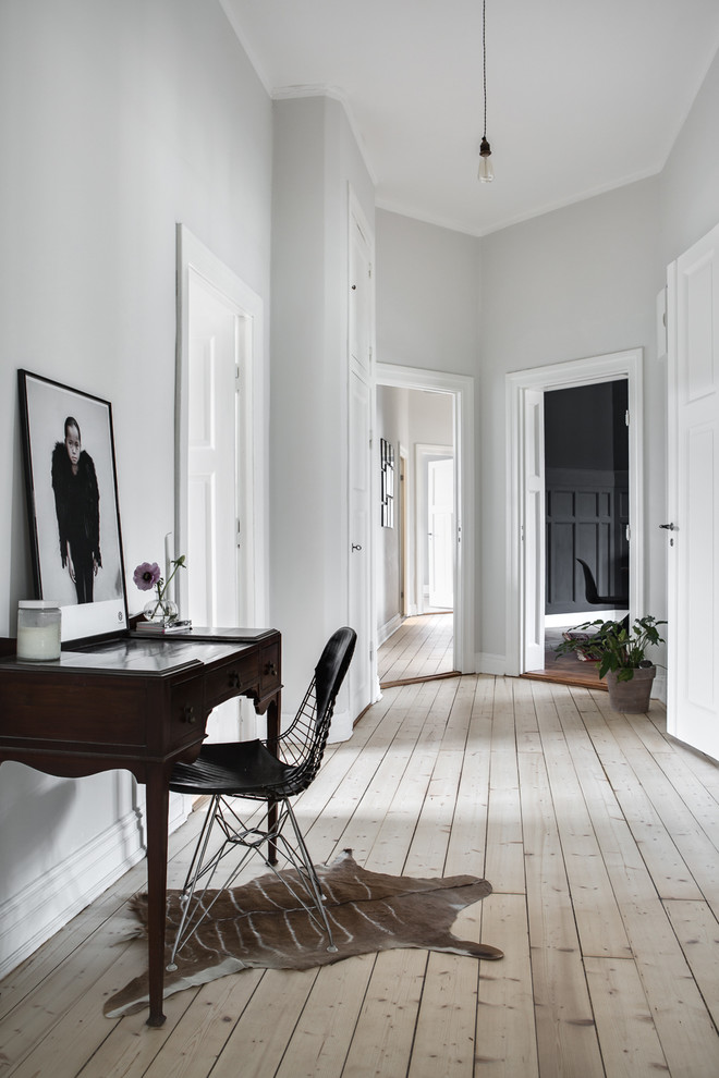 This is an example of a mid-sized scandinavian hallway in London with grey walls and light hardwood floors.