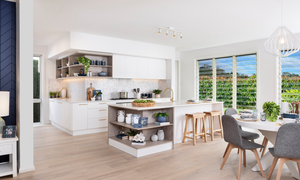 Inspiration for a large contemporary l-shaped open plan kitchen in Other with an integrated sink, shaker cabinets, white cabinets, quartz benchtops, grey splashback, ceramic splashback, panelled appliances, light hardwood floors, with island, beige floor and white benchtop.