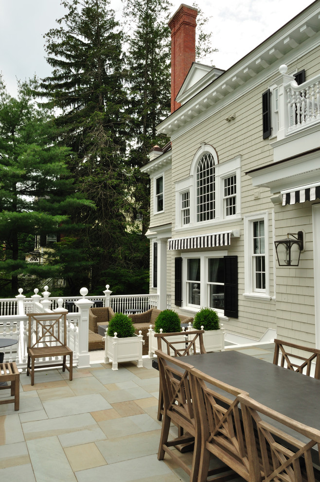 Photo of a large traditional backyard deck in New York with an awning.