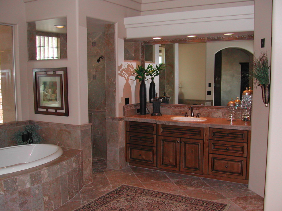 Inspiration for a mid-sized transitional master beige tile and stone tile travertine floor drop-in bathtub remodel in Phoenix with a drop-in sink, raised-panel cabinets, dark wood cabinets, granite countertops and beige walls