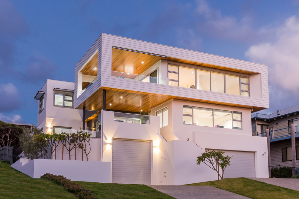 This is an example of a large contemporary three-storey white house exterior in Perth with mixed siding and a flat roof.