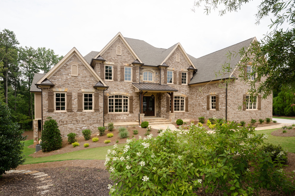 Photo of an expansive transitional three-storey brick brown exterior in Atlanta with a gable roof.