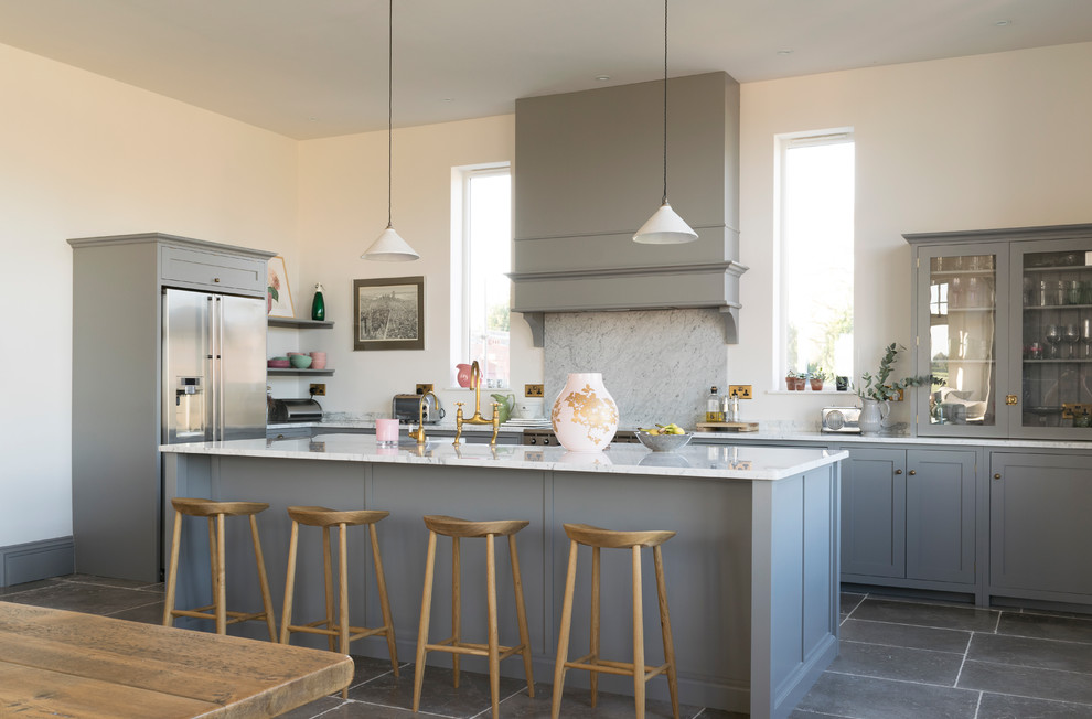 Photo of a large transitional l-shaped open plan kitchen in Other with shaker cabinets, grey cabinets, quartzite benchtops, white splashback, marble splashback, stainless steel appliances, limestone floors, with island and grey floor.