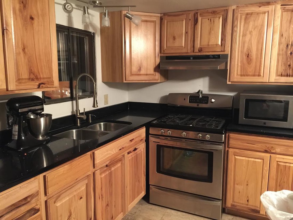 Example of a mid-sized transitional l-shaped porcelain tile enclosed kitchen design in Austin with a double-bowl sink, beaded inset cabinets, dark wood cabinets, granite countertops, beige backsplash, stone tile backsplash, stainless steel appliances and a peninsula
