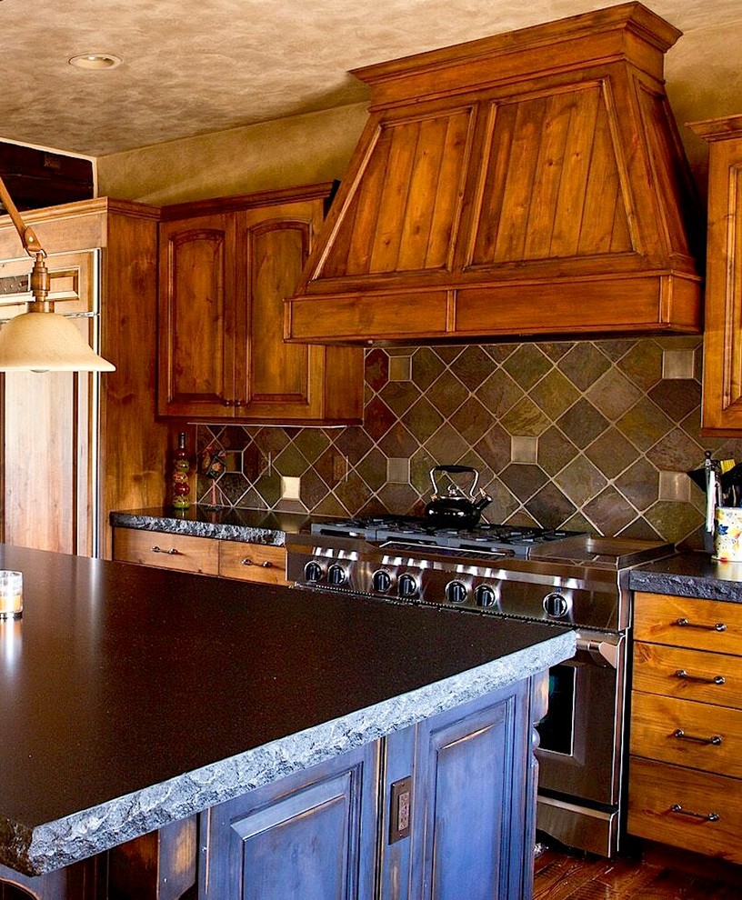 This is an example of a mid-sized country l-shaped open plan kitchen in Detroit with an undermount sink, raised-panel cabinets, medium wood cabinets, granite benchtops, multi-coloured splashback, ceramic splashback, stainless steel appliances, medium hardwood floors, with island and brown floor.
