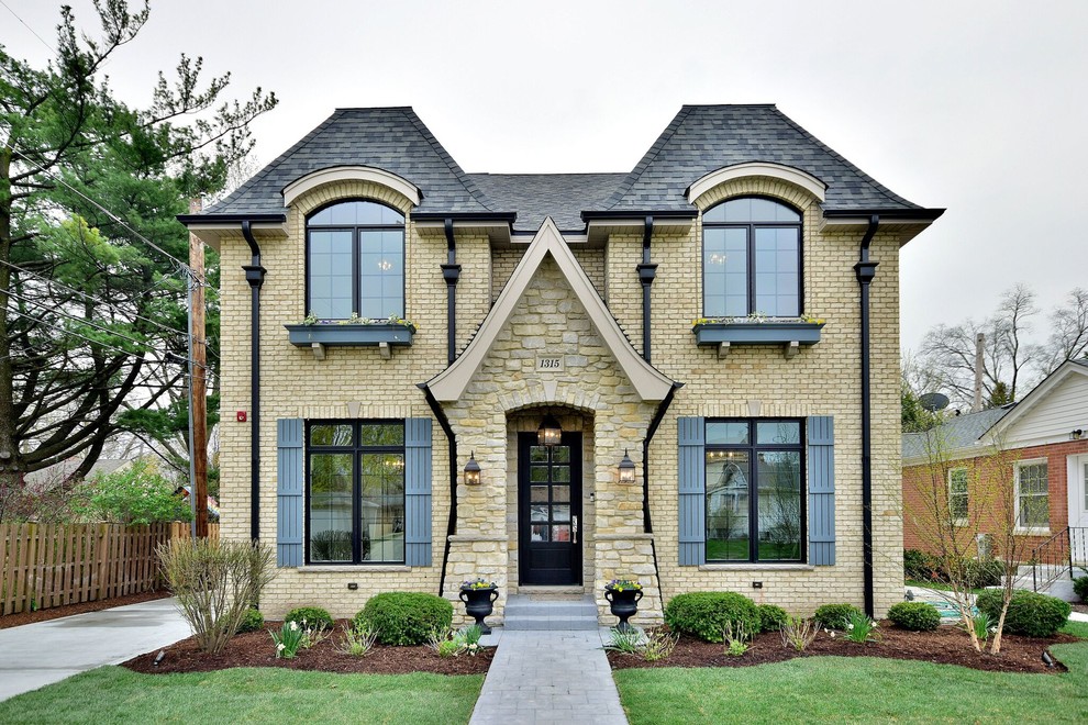 Inspiration for a traditional two-storey brick beige house exterior in Chicago with a hip roof and a shingle roof.