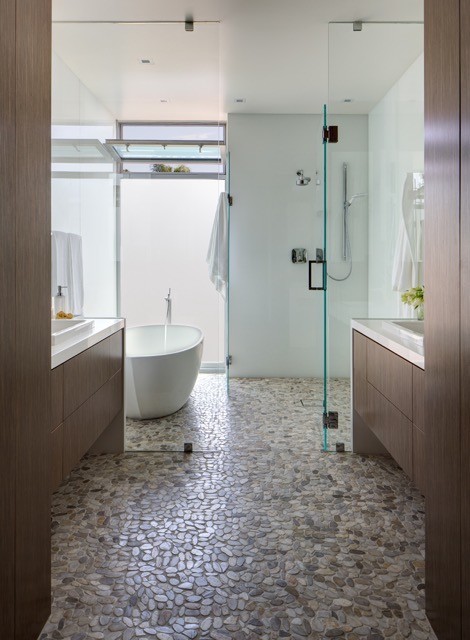 This is an example of a large contemporary master bathroom in San Diego with flat-panel cabinets, medium wood cabinets, a freestanding tub, pebble tile, pebble tile floors, a drop-in sink and a curbless shower.