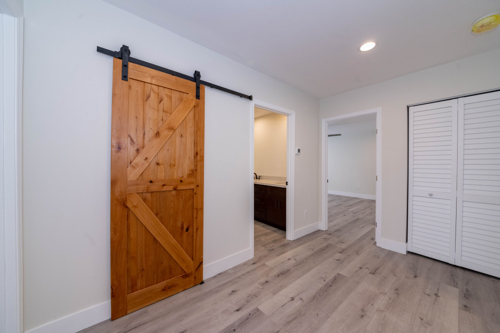 Photo of a large modern hallway in Los Angeles with white walls, light hardwood floors, grey floor and recessed.