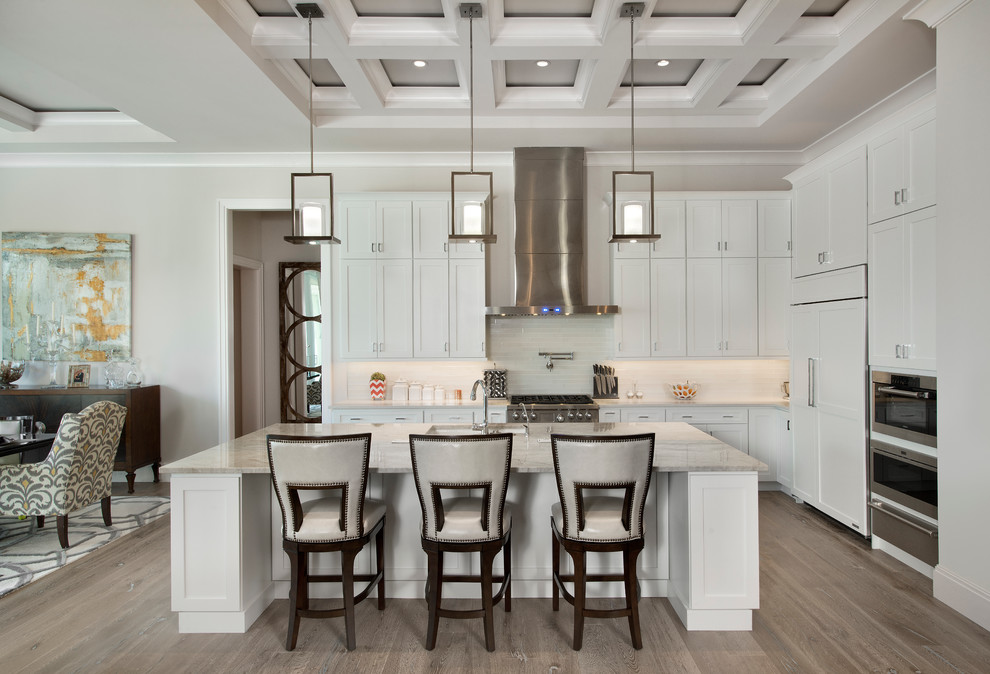 Example of a large transitional l-shaped light wood floor open concept kitchen design in Miami with an undermount sink, white cabinets, quartzite countertops, white backsplash, subway tile backsplash, stainless steel appliances, an island and shaker cabinets