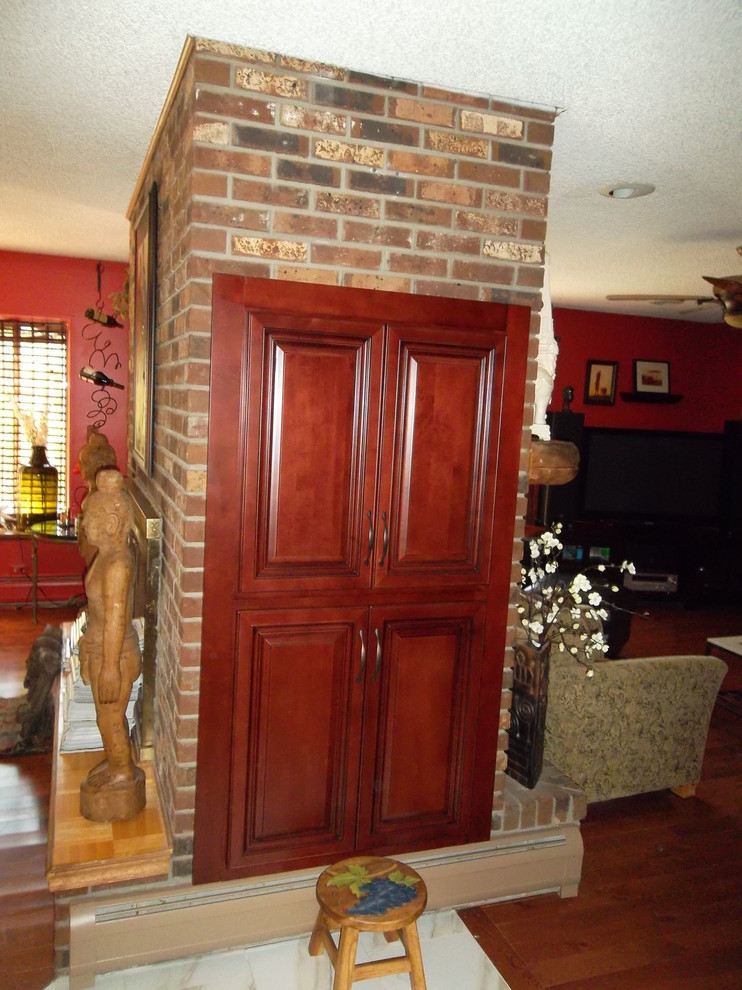 Inspiration for a mid-sized transitional l-shaped ceramic tile kitchen remodel with a drop-in sink, dark wood cabinets, granite countertops, stone tile backsplash, stainless steel appliances, an island and raised-panel cabinets